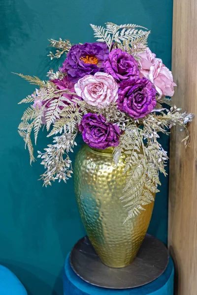 部屋の隅にある黄金の花瓶の人工花 — ストック写真