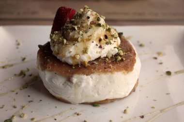 Lübnanlı bir tatlı ashta ve vanilyalı dondurma ile antep fıstığı yapılmış ve bal ile drizzled.