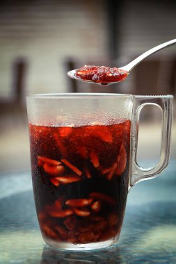 Bir kaşık jallab uzun bir cam yukarıda. Jallab bir serinletici yaz, Ramazan boyunca popüler içecektir. Üzüm, Keçiboynuzu Pekmezi, tarihler ve gül suyu ile yapılır. Ezilmiş buz, fındık ve kuru üzüm ile suda seyreltilmiş.