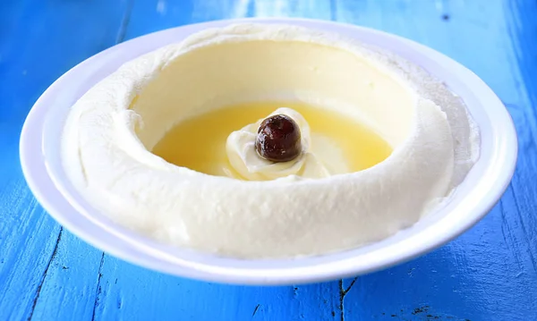 Bir taze labneh tabak Zeytinyağlı bir rustik mavi ahşap masa.