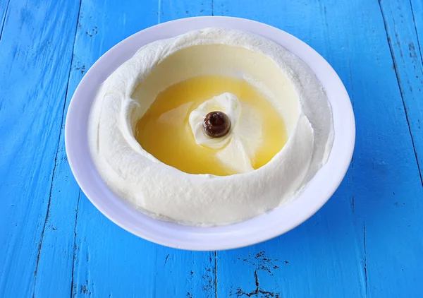 Bir taze labneh tabak Zeytinyağlı bir rustik mavi ahşap masa.