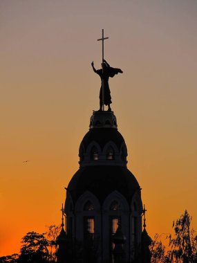 John the Baptist Dnepropetrovsk (Ukrayna), gün batımında siluet tapınakta üzerinde heykeli                    