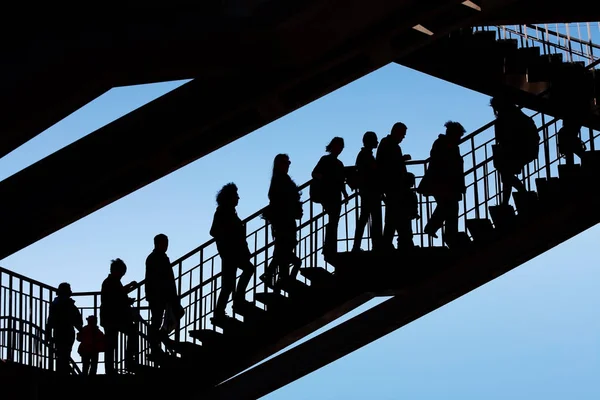 Silhouettes of people on the stairs against the sky