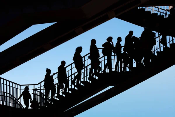 Silhouettes of people on the stairs against the sky