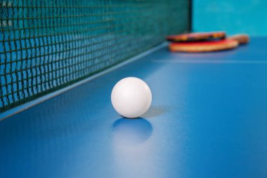 Masa tenisi için raketler ve tenis masasında bir top.