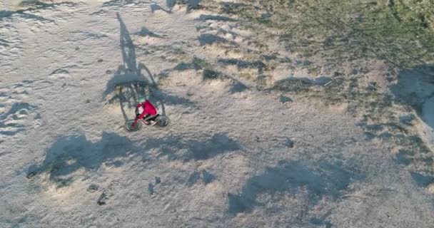男性サイクリストは夕焼けに長い影とオーバーヘッド撮北コロラド州プレイリーの起伏の多い地形で脂肪自転車に乗ってください — ストック動画