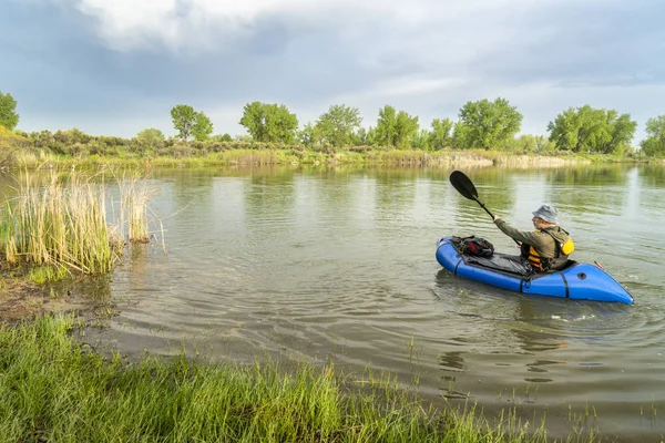 春の風景にコロラド州の湖の青 Pacraft 単身光いかだ遠征やアドベンチャー レース用 をパドリング シニア男性 — ストック写真