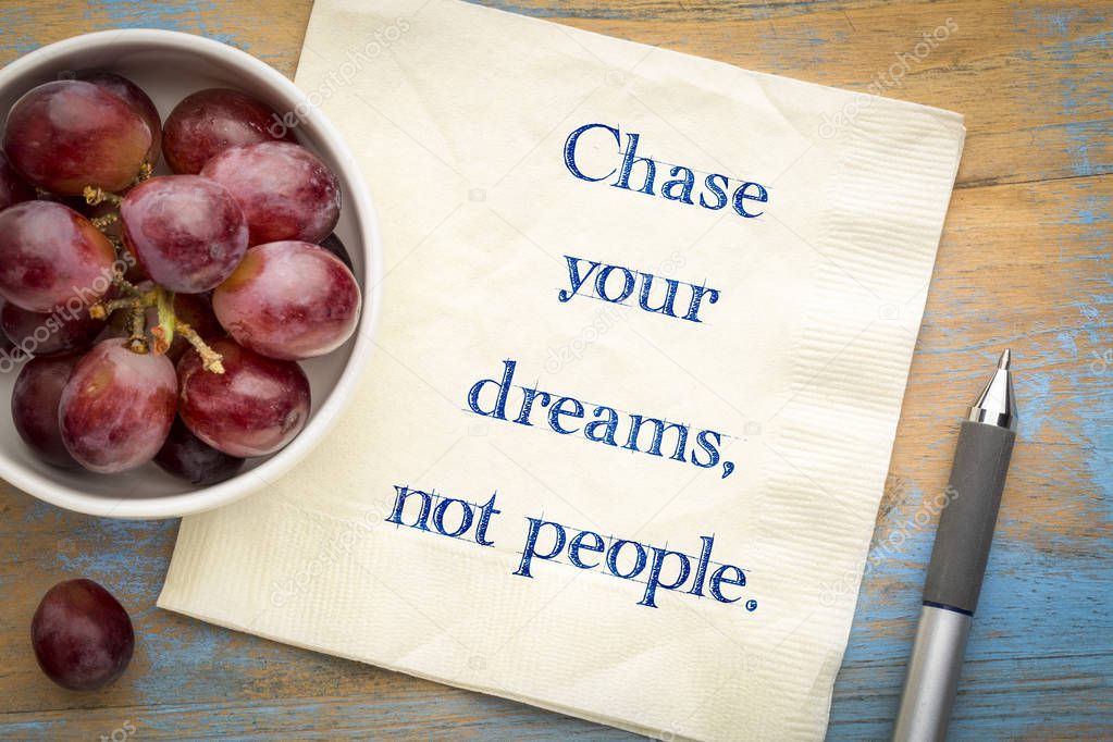 Chase your dreams, not people - inspirational handwriting on a napkin with grapes