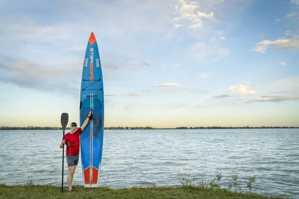 彼のレースのシニア卓球選手は日没のトレーニングの後ボイド岸湖で右舷で Paddleboard に立ち上がるラブランド コロラド州 アメリカ合衆国 2018 — ストック写真