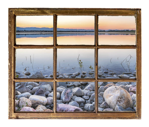 Dusk over a lake in Colorado foothills and Rocky Mountains as seen through a vintage sash window