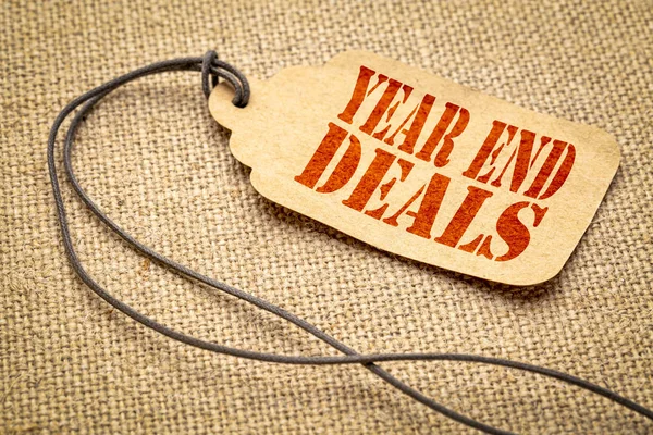 year end deals sign - a paper price tag with a twine iagainst burlap canvas