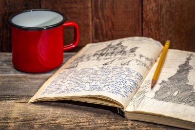 Vintage sefer journal metal bir fincan sıcak çay ile bir rustik ahşap tablo - el yazısı ve pencil.from içinde bir kayık gezisi Polonya 1970 yazında çizim.