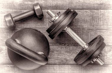 demir kettlebell ve halter rustik ahşap arka plan, siyah beyaz resmi - fitness kavramı üzerine