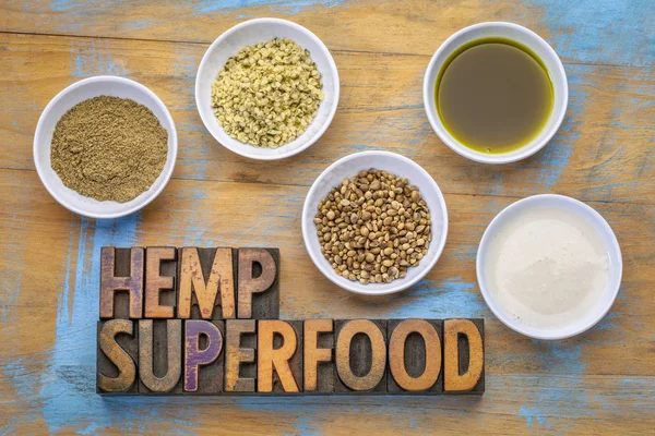 collection of hemp seed products: hearts, protein powder, milk and oil in small white bowls with a text in vintage letterpress wood type