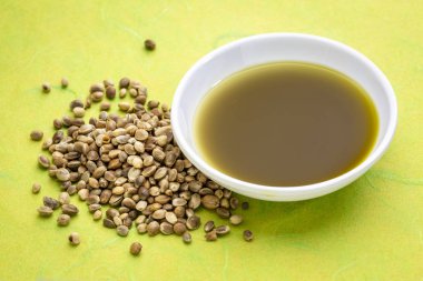 Kenevir tohumu ve yeşil Dut kağıt karşı küçük bir kasede yağ Kuru