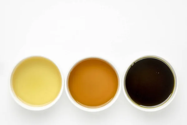 从鳄梨 黑种子和大麻种子健康油 在白色的艺术画布上的陶瓷碗的顶部视图与复制空间 — 图库照片