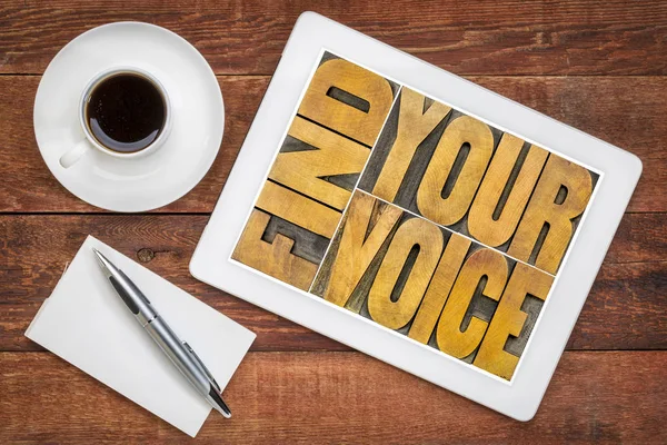 find your voice creativity concept - text  in vintage letterpress wood type on a digital tablet with a cup of coffee