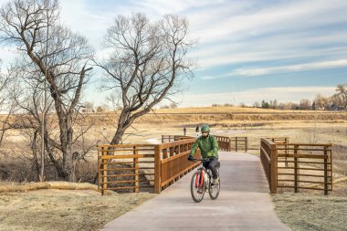 olgun erkek bisikletçi tipik kış sahne Fort Collins Kuzey Colorado karda olmadan yeni inşa edilmiş bisiklet yolu üzerinde