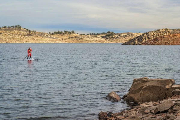 Colorado - erkek paddler bir drysuit Horsetooth rezervuar üzerinde kürek çekmeye kadar kış stand