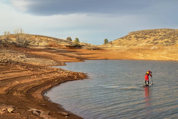 コロラド州 Horsetooth 貯水池でドライスーツで男性カヌーを漕ぐ人のパドリングを冬スタンド — ストック写真