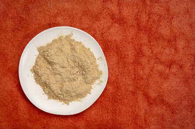 Maca kökü Toz kırmızı dokulu kağıt kopya alanı ile karşı beyaz seramik plaka üzerinde
