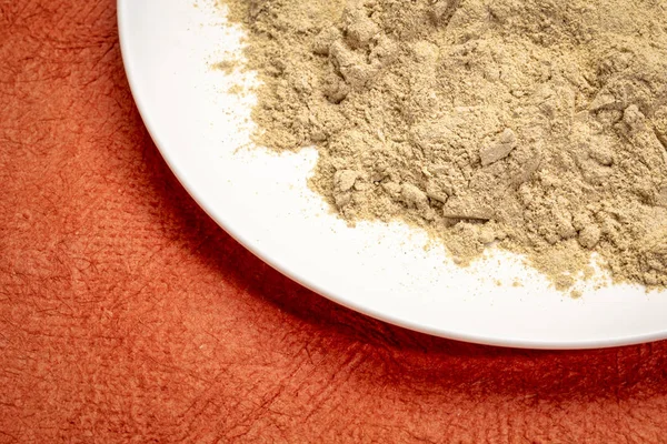 Maca Polvere Radice Piatto Ceramica Bianca Contro Carta Strutturata Rossa — Foto Stock