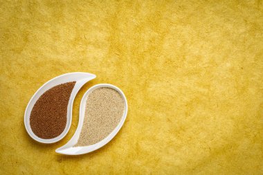 gluten ücretsiz kahverengi ve sarı dokulu kağıt - Etiyopya ve Eritre önemli gıda tahıl karşı bowll Fildişi teff tahıl üzerinde gözyaşı şeklinde