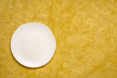 El yapımı Huun Maya Kağıt kopya alanı ile sarı bir ayçiçeği düzensiz bir kenar ile beyaz seramik tabak