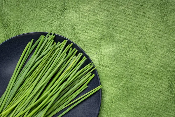 Groene bieslook op zwarte plaat — Stockfoto