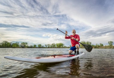 Kıdemli erkek paddler üzerinde SUP Paddleboard