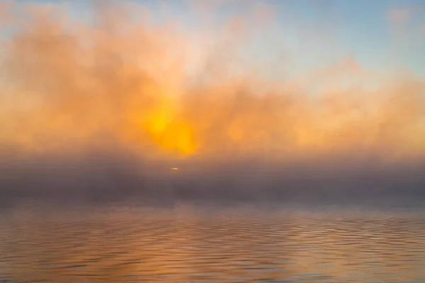 Nebuloso nascer do sol sobre um rio — Fotografia de Stock