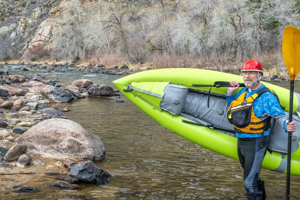 Maggiore paddler che trasporta kayak gonfiabile whitewater Foto Stock