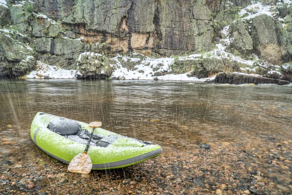 Inflatable whitewater kayak in spring snowstorm — Stock Photo, Image