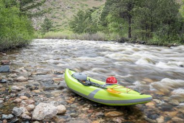inflatable whitewater kayak on mountain river clipart