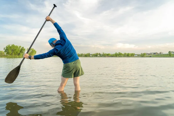 Stand up paddler is stretching — Stock Photo, Image