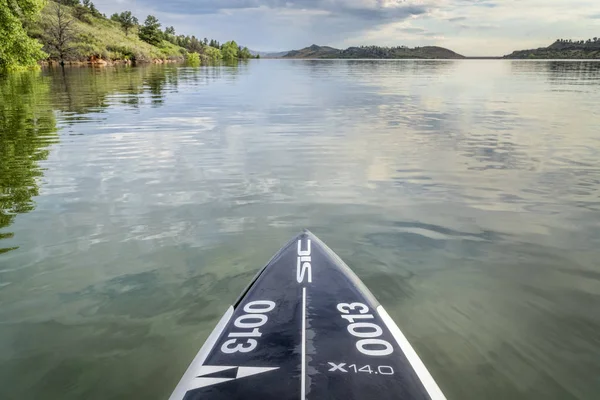 パフォーマンスは湖のパドルボードを立ち上がる — ストック写真