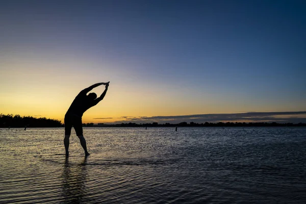 湖の上の男の日の出のシルエット — ストック写真