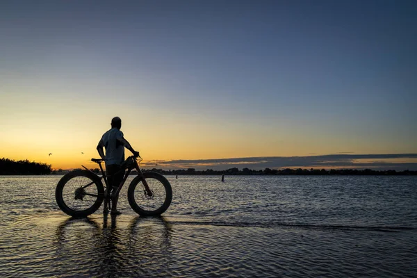 Fatbike ile bir adamın gündoğumu silueti — Stok fotoğraf