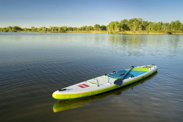 Inflável stand up paddleboard flutuando no lago — Fotografia de Stock