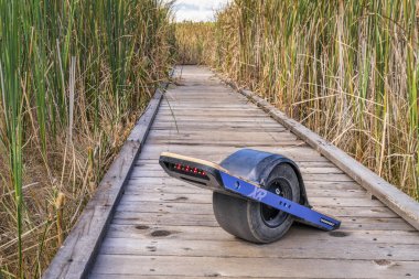 boardwalk üzerinde onewheel elektrikli kaykay