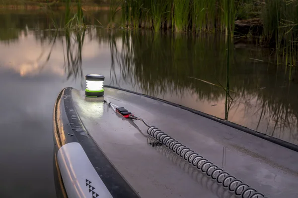 Stand-up paddleboard avec une lanterne au crépuscule — Photo