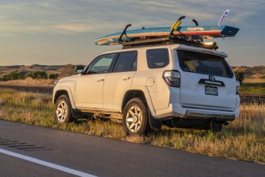 Toyota 4runner with paddleboard in Nebraska Sandhills clipart