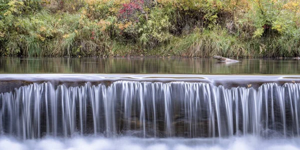Água em cascata sobre uma barragem de desvio de rio — Fotografia de Stock