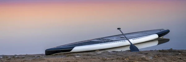 Crepuscolo sul lago con un paddleboard — Foto Stock