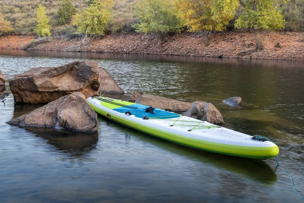 Inflatable stand up paddleboard  on mountain lake — Stock Photo, Image