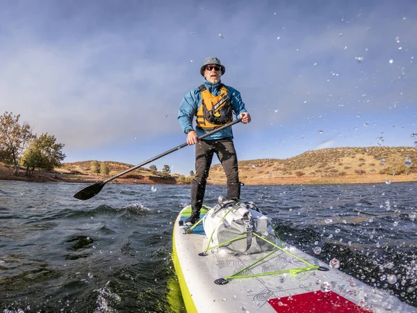 Starszy człowiek Wiosłowanie a Stand w górę paddleboard — Zdjęcie stockowe