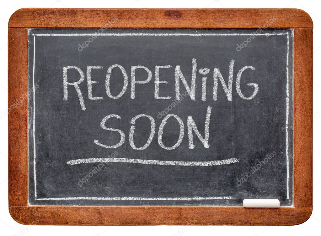 reopening soon - white chalk handwriting on a slate blackboard, business opening after coronavirus covid-19 pandemic and social distancing