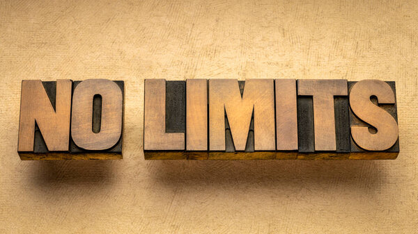 без ограничений - вдохновляющее слово абстрактный в винтажном типе почтового пресса древесины, бизнеса, образования или концепции личностного развития
