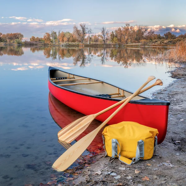 湖のほとりにある木製のパドルと乾いた袋を持つ赤いタンデムカヌー コロラド州の秋の風景 — ストック写真