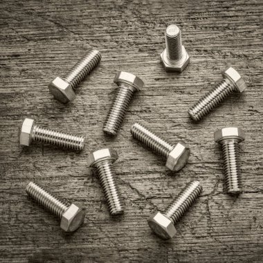 Kırsal ahşap, siyah ve beyaz görüntüye karşı on tane paslanmaz çelik cıvata seti.